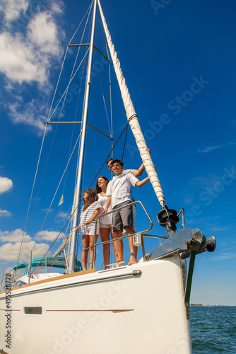 Latin American family standing on bow of yacht