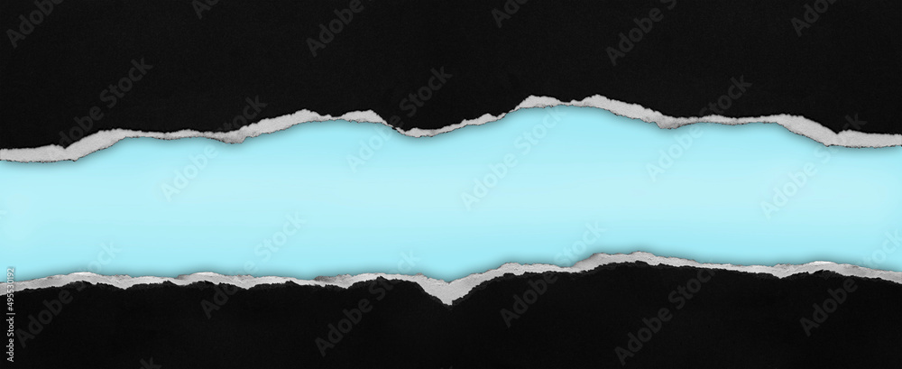 Ripped black paper on blue background, space for copy