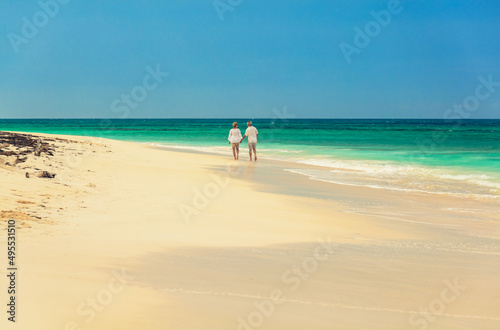 Tropical beach with retired couple on shoreline Bahamas