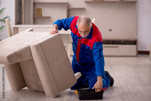 Old male carpenter working indoors