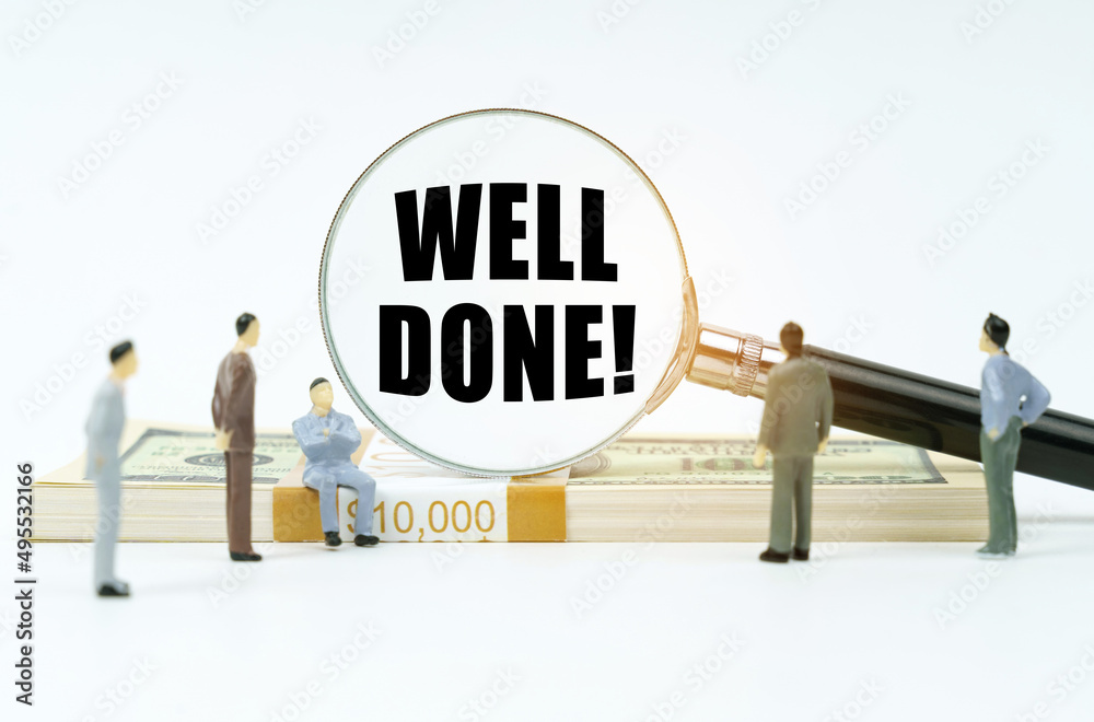 On a white surface, a dollar, figurines of people and a magnifying glass with the inscription - WELL DONE On a white surface, a dollar, figurines of people and a magnifying glass with the inscription - WELL DONE