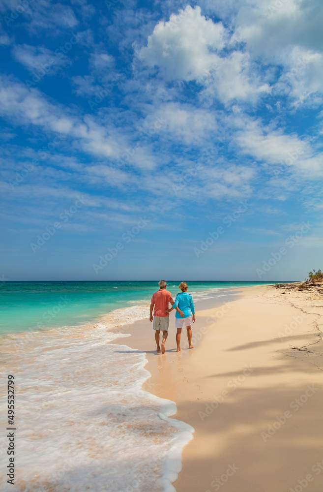 Ocean waves on beach with couple holding hands