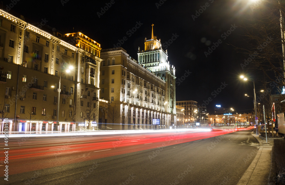 Moscow, Russia, Mar 3, 2022: Night view of Garden Ring near Triumphalnaya square. Hotel 'Peking' soviet skyscraper building. Car traces