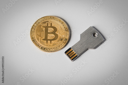 Bitkoin coin and usb memory card on a white background. Cryptocurrency storage photo