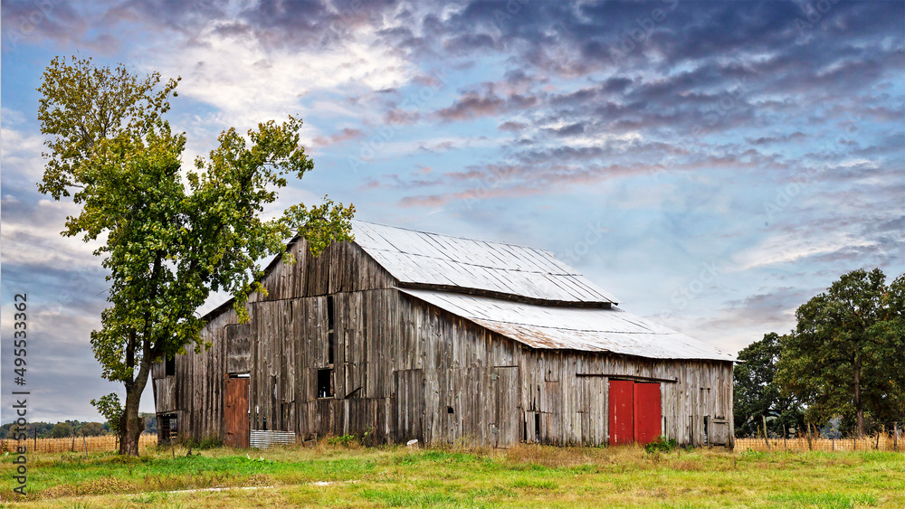 Obraz premium Rural countryside farm landscape with aging barn 