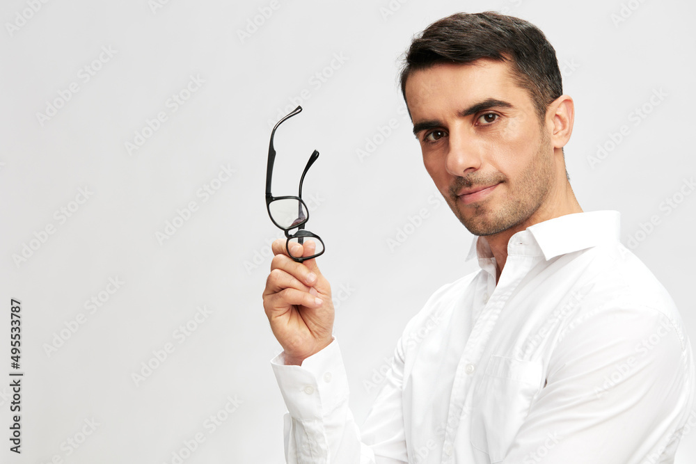 successful man holding glasses in hand in white shirts hand gesture copy-space isolated background