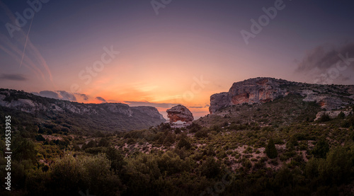 Sunset in the mountains. A stone arch in the middle of the mountain. rocky landscape