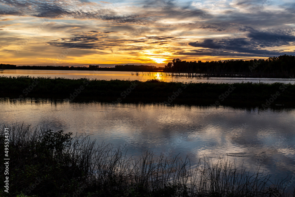 Wetland conservation area near St. Charles, MO at sunset with clouds reflected in calm water
