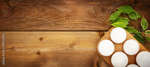 White eggs in a wooden stand on a wooden background