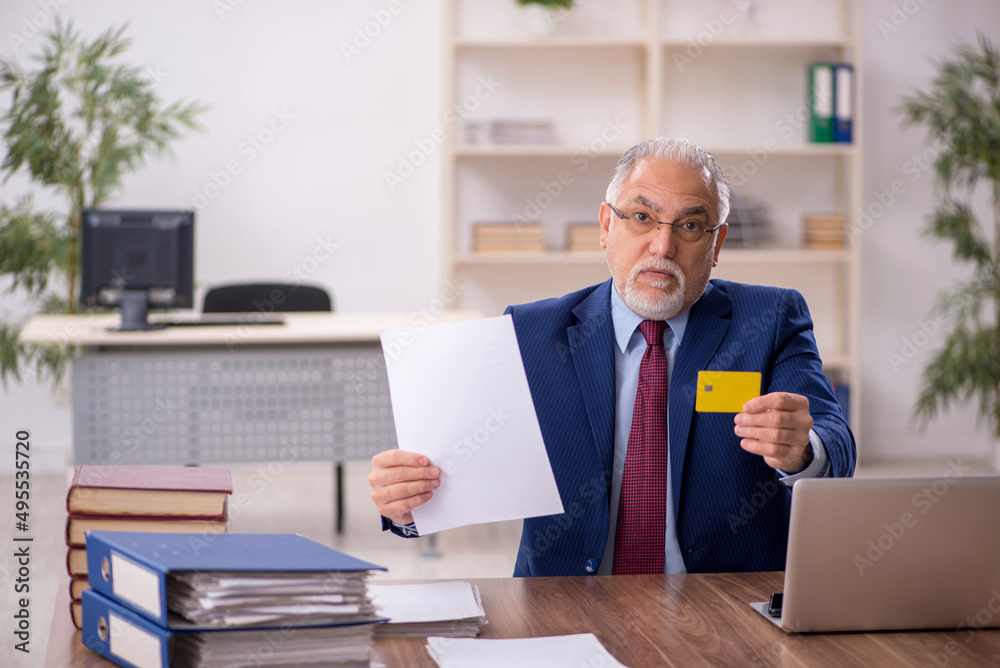 Old male employee working at workplace Old male employee working at workplace