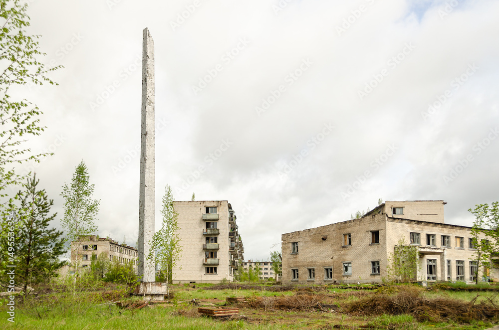 Abandoned white brick multistorey houses and monument. Forgotten, abandoned ghost town Skrunda, Latvia. Former Soviet army radar station.