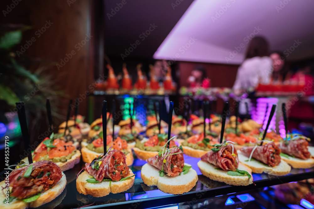 Decorated catering banquet table with different food snacks and appetizers with sandwich