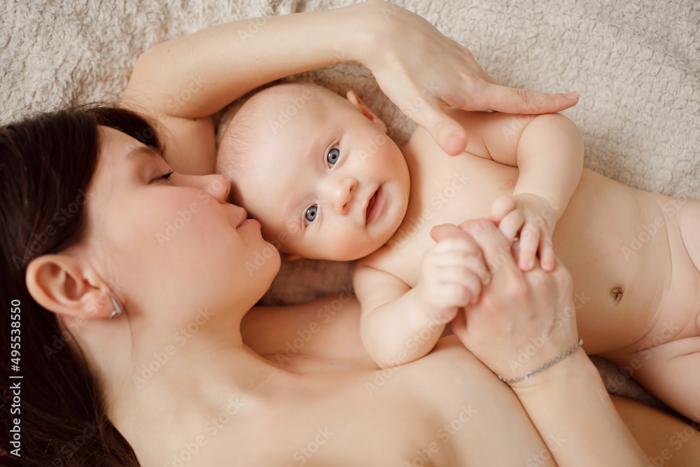 a naked mother and the baby on the bed. maternal and child health. a naked mother and the baby on the bed. maternal and child health.