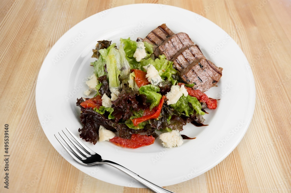 Roast rib steak, fried beef meat on a plate with salad.