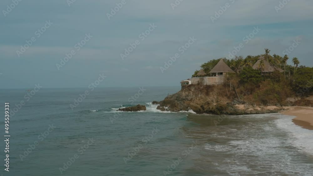 Eco style abandoned villa in the jungle with mountainous terrain. drone flies over Pacific Ocean coastline with crashing waves and sandy beaches. touristic destination in Mexico Eco style abandoned villa in the jungle with mountainous terrain. drone flies over Pacific Ocean coastline with crashing waves and sandy beaches. touristic destination in Mexico