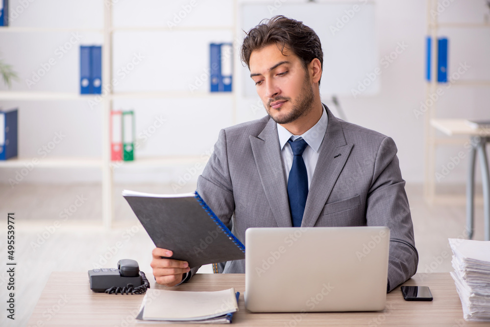 Young male employee sitting at workplace Young male employee sitting at workplace