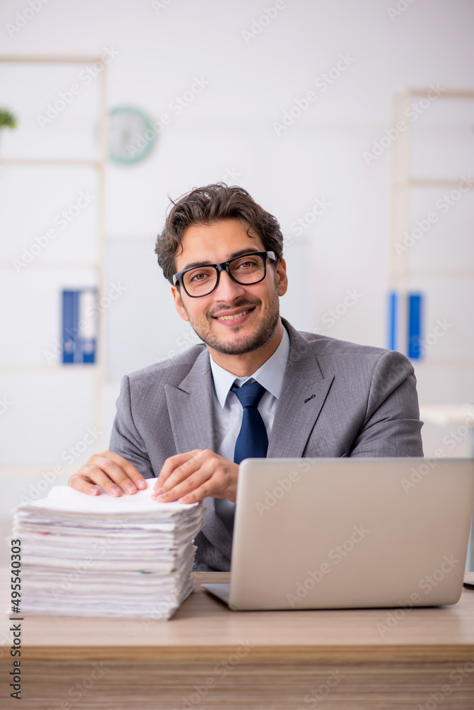 Young male employee sitting at workplace