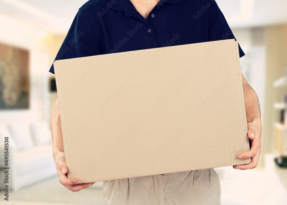 Male employee courier hold in hand brown clear blank paper empty cardboard box Male employee courier hold in hand brown clear blank paper empty cardboard box