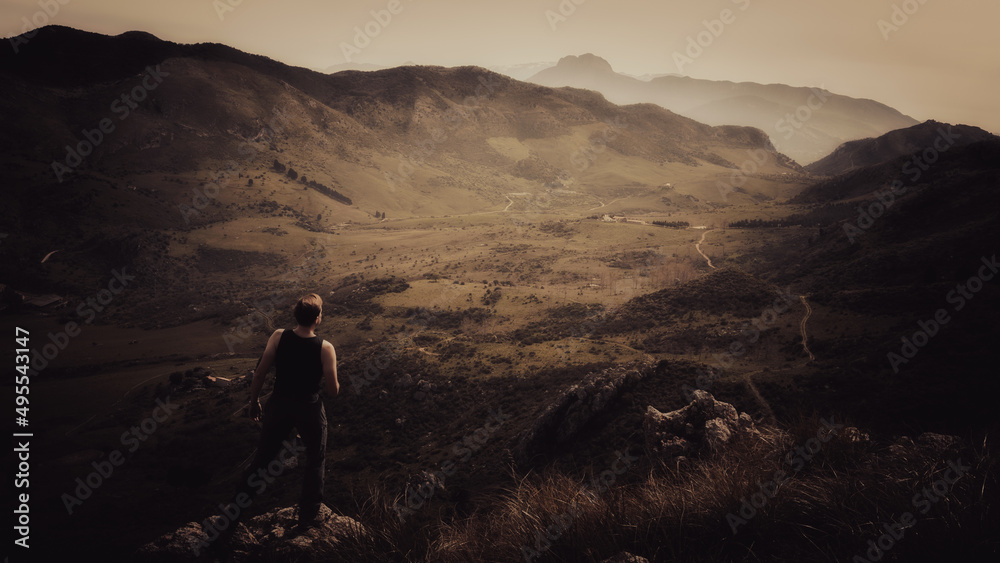 Young Man hiking in the mountains of Sicily in italian Europe on a lovely warm day