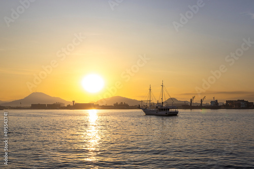 Sol nascendo com um barco de pesca ancorado