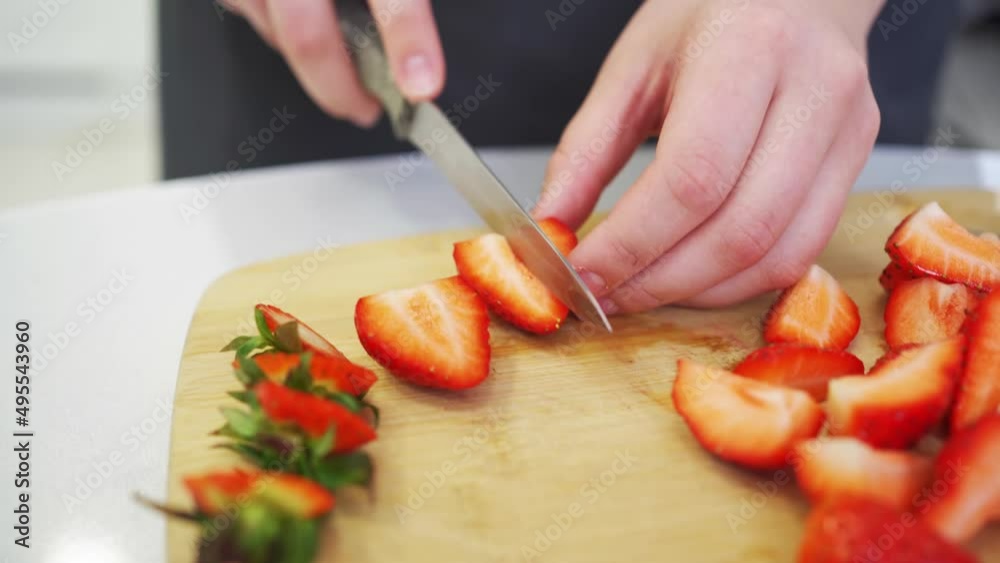 strawberries are cut into pieces on a wooden cutting board to decorate desserts. strawberries are cut into pieces on a wooden cutting board to decorate desserts.