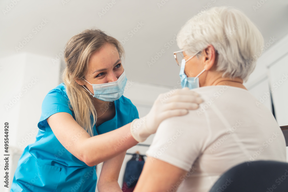 Friendly caucasian nurse supporting an elderly retired lady. . High quality photo