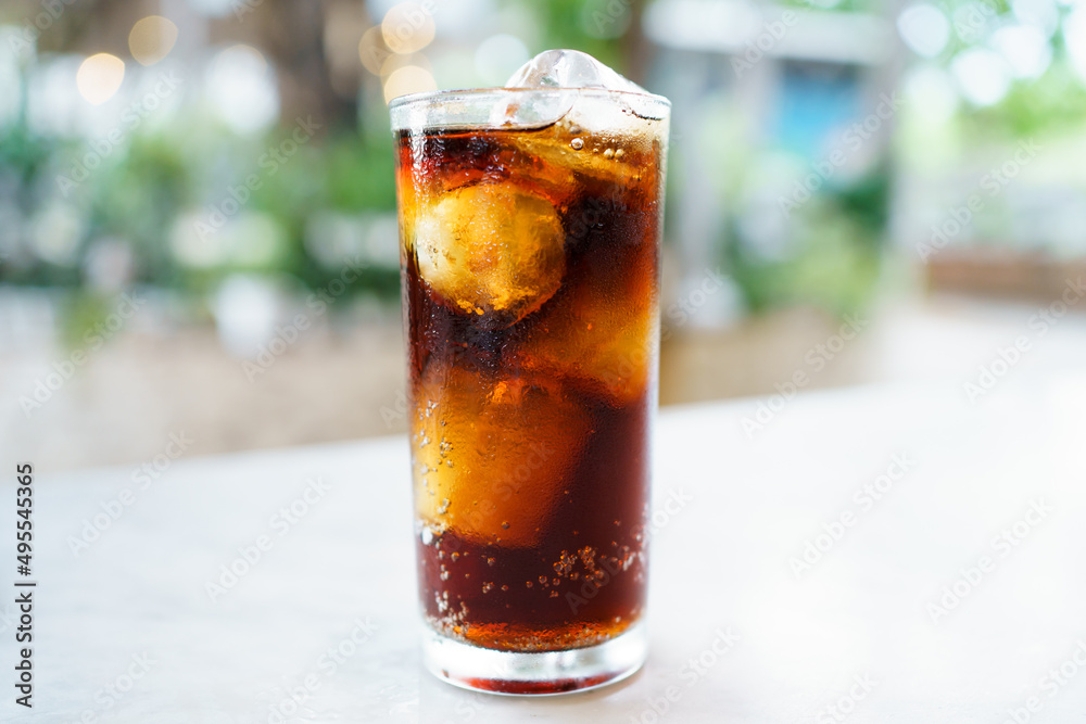 Close up shoot with copyspace of cola soda with ice in a drinking glass. Sparkling cola filled in the glass with ice. Close up shoot with copyspace of cola soda with ice in a drinking glass. Sparkling cola filled in the glass with ice.