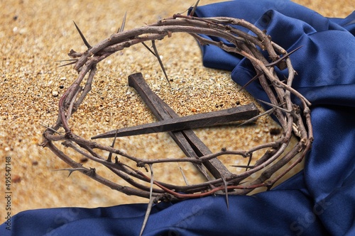 Christian crown of thorns with metal nails on a wooden desk