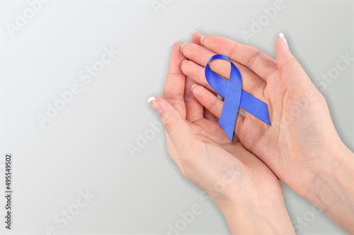 Hope and World cancer day concept. Woman holding dark Blue Ribbon for supporting people illness.