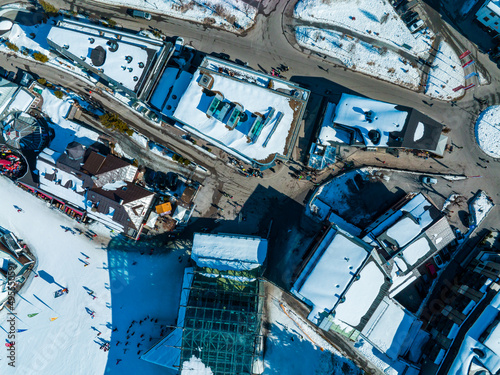 Ski resort town of St. Anton am Arlberg in Austria with amazing winter sunny sky and snowy mountains covered with pine trees in the background © Aerial Film Studio