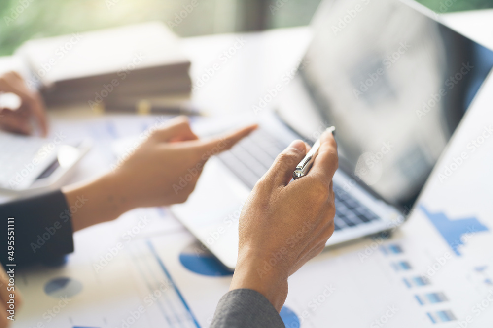 Close up of hands of two men and woman wearing casual clothes working with graphs at a white table and making notes. Locked down real time close up shot Close up of hands of two men and woman wearing casual clothes working with graphs at a white table and making notes. Locked down real time close up shot