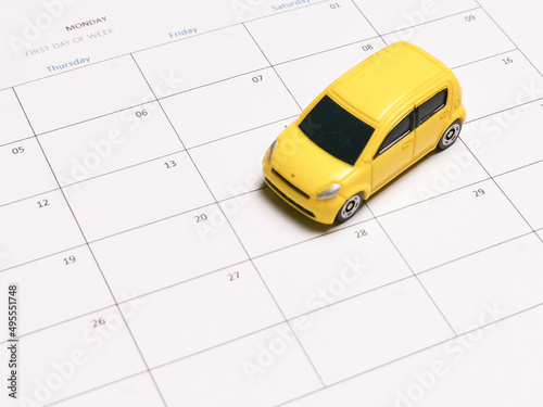 Miniature car on blank calender. Loan payment or maintenance schedule concept.