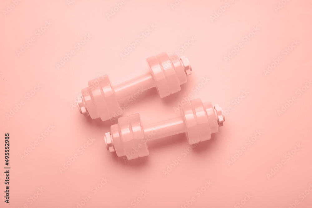 Pair of dumbbells on pink background Pair of dumbbells on pink background