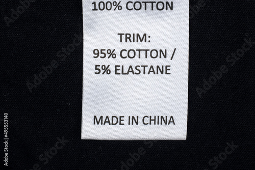 Made in china clothes label on a black background. 100% Cotton Clothing. photo