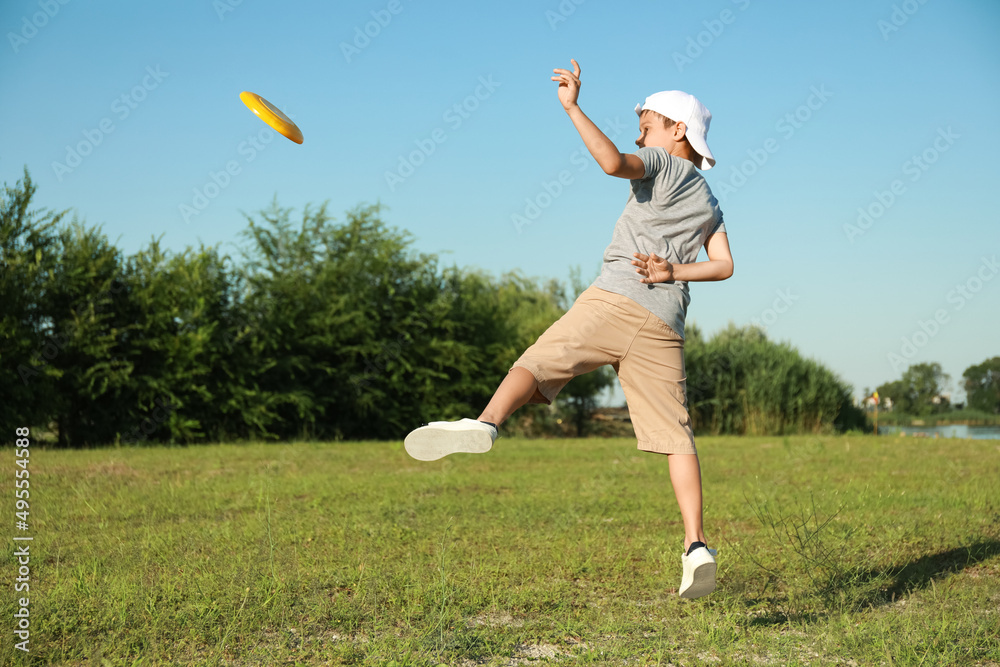 Cute little boy playing frisbee outdoors Cute little boy playing frisbee outdoors