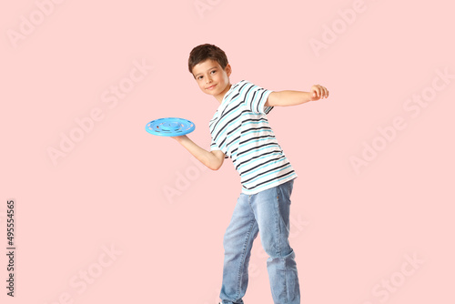 Funny little boy playing frisbee on color background © Pixel-Shot