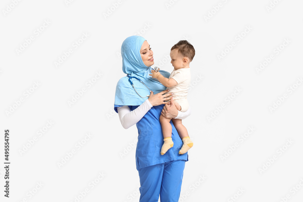 Muslim pediatrician with baby boy on light background