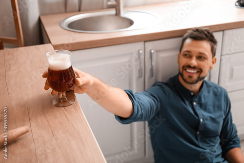 Handsome man taking glass o...