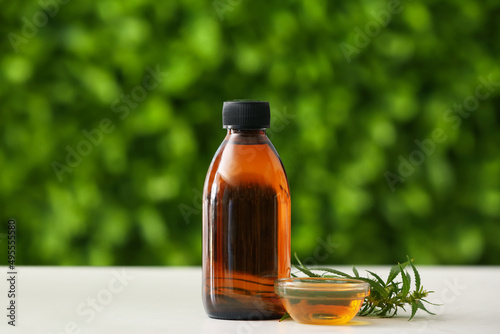 Bottle of CBD oil on table outdoors