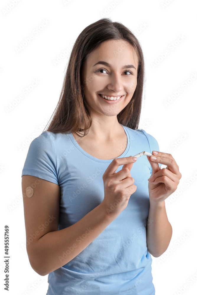 Young woman with applied nicotine patch and broken cigarette on white background. Smoking cessation Young woman with applied nicotine patch and broken cigarette on white background. Smoking cessation