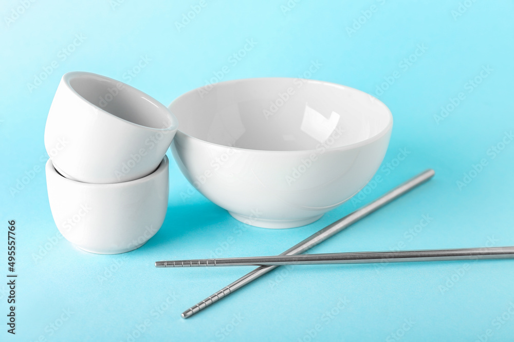 Chinese bowls with chopsticks on color background Chinese bowls with chopsticks on color background