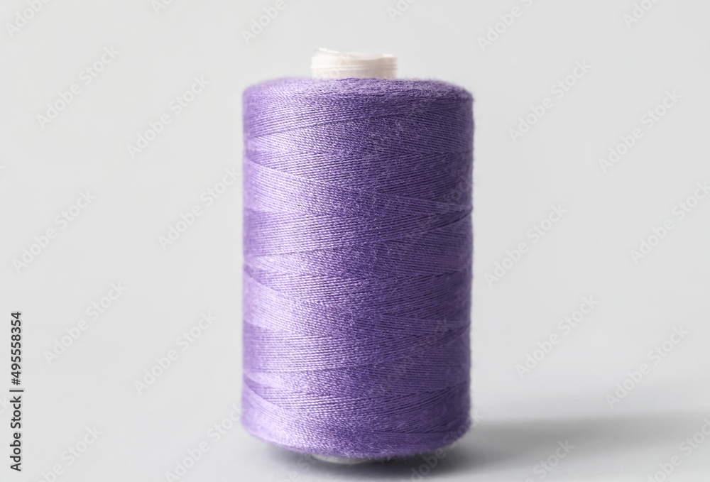 Purple sewing thread spool on light background Purple sewing thread spool on light background