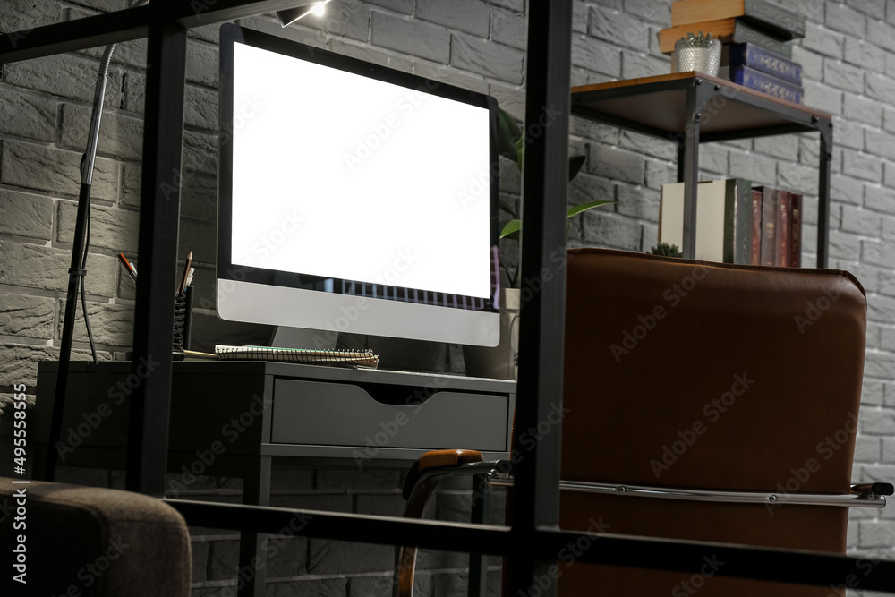 Fototapeta premium Workplace with modern computer near grey brick wall