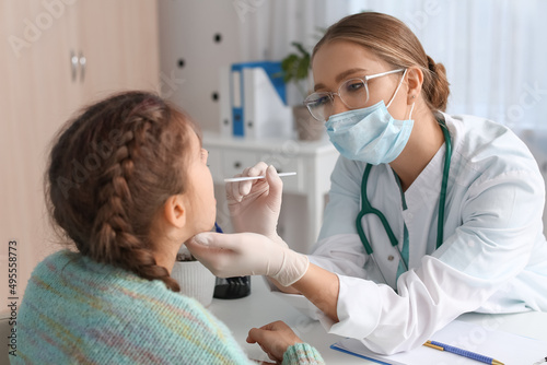 Doctor examining little gir...