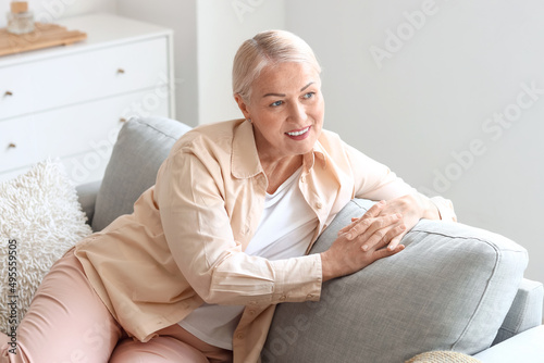 Mature woman sitting on soft sofa © Pixel-Shot