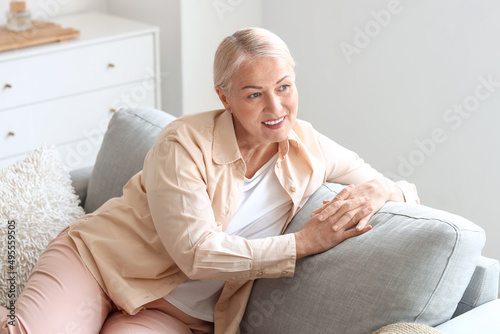 Mature woman sitting on sof...