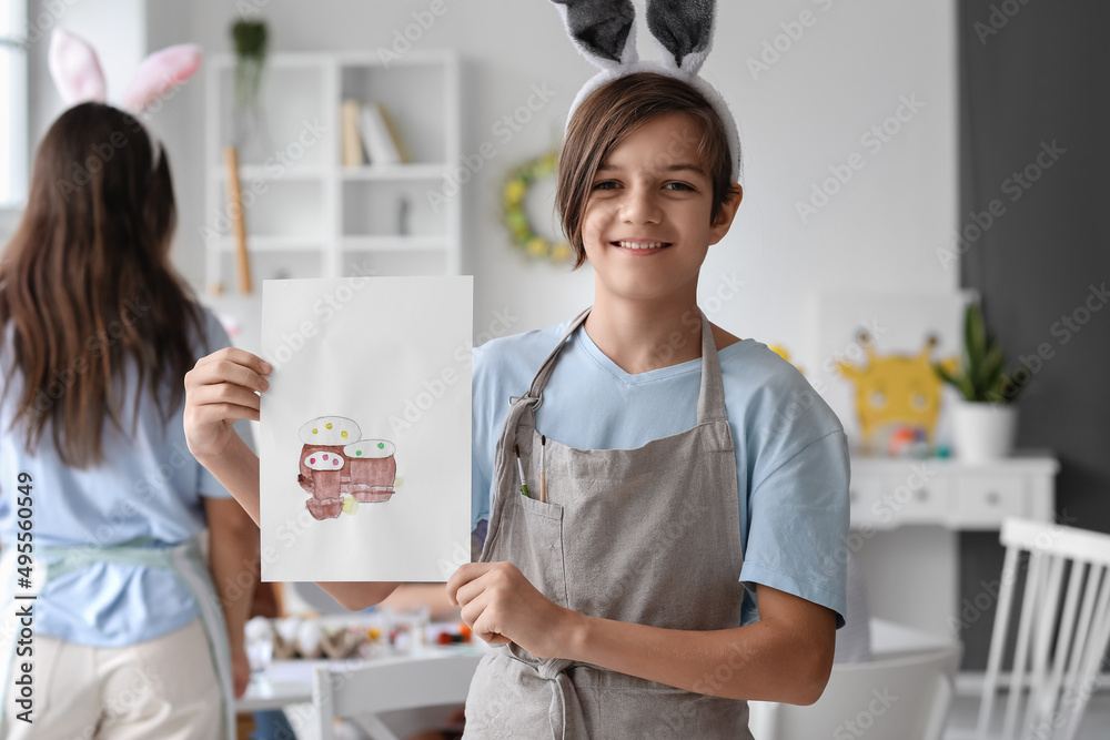 Cute boy with picture of Easter cakes painted during master-class in art Cute boy with picture of Easter cakes painted during master-class in art