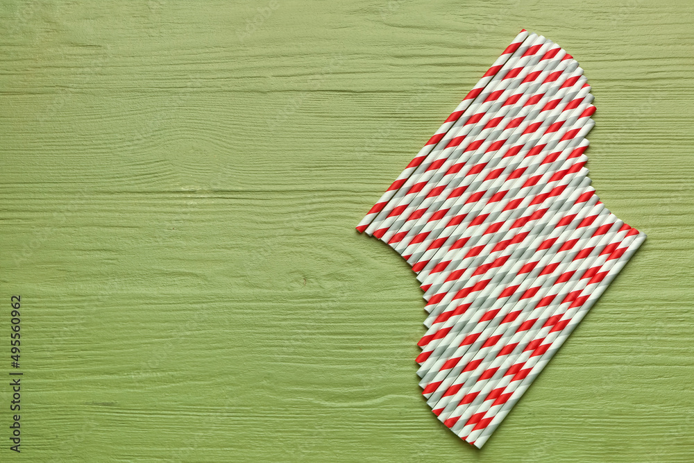 Stylish straws for drinks on green wooden background Stylish straws for drinks on green wooden background