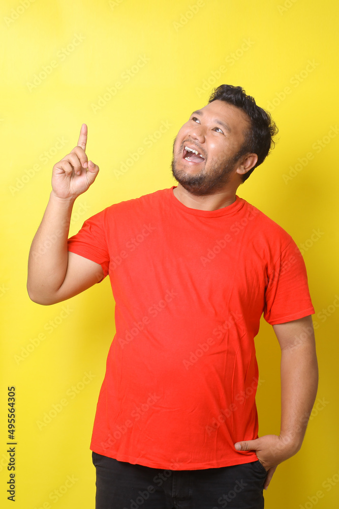 Great idea concept. Young funny Asian fat man pointing finger up, he got solution to his problem, having Aha moment, isolated on yellow studio background. Wow, Eureka Great idea concept. Young funny Asian fat man pointing finger up, he got solution to his problem, having Aha moment, isolated on yellow studio background. Wow, Eureka