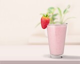 Glass of strawberry yogurt on color pastel  background